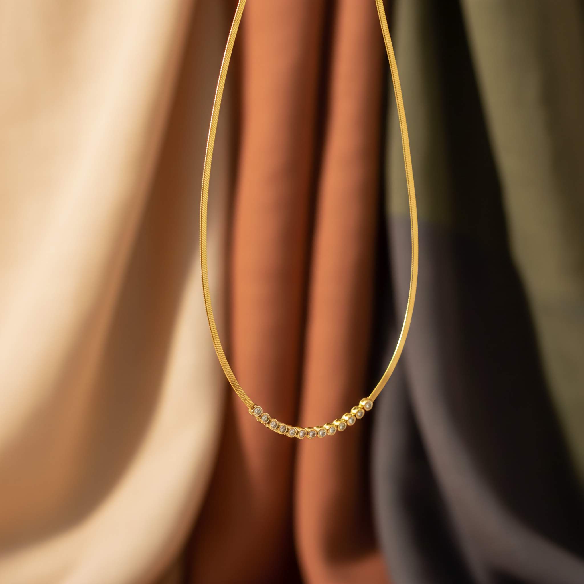 Gold necklace on a soft fabric background