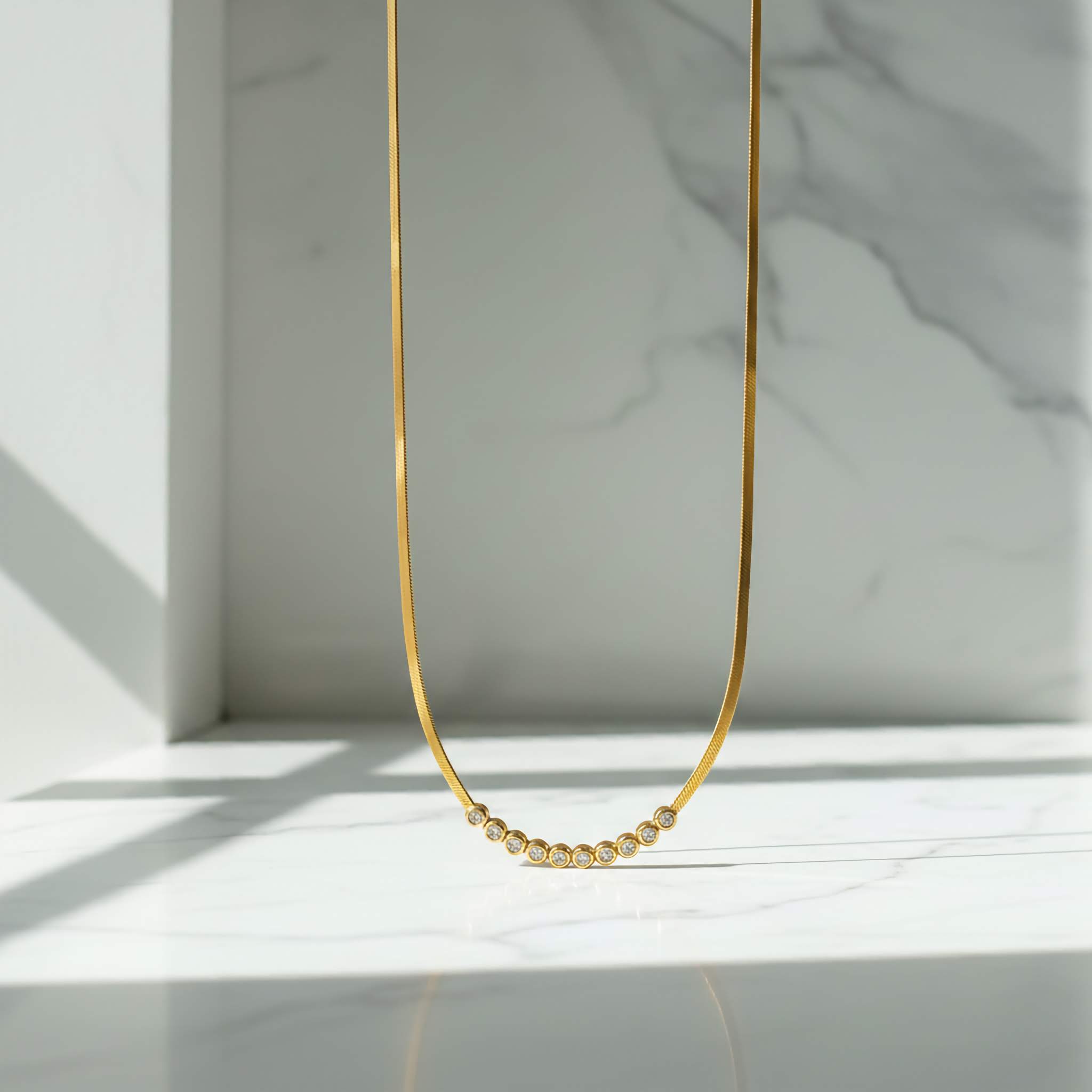 Clear Zirconia 18k Gold plated necklace on a light marble background