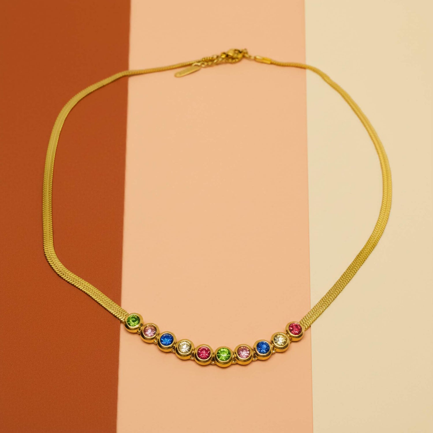 Imitation jewelry materials: gold mesh necklace adorned with colorful gemstones on a stylish backdrop.