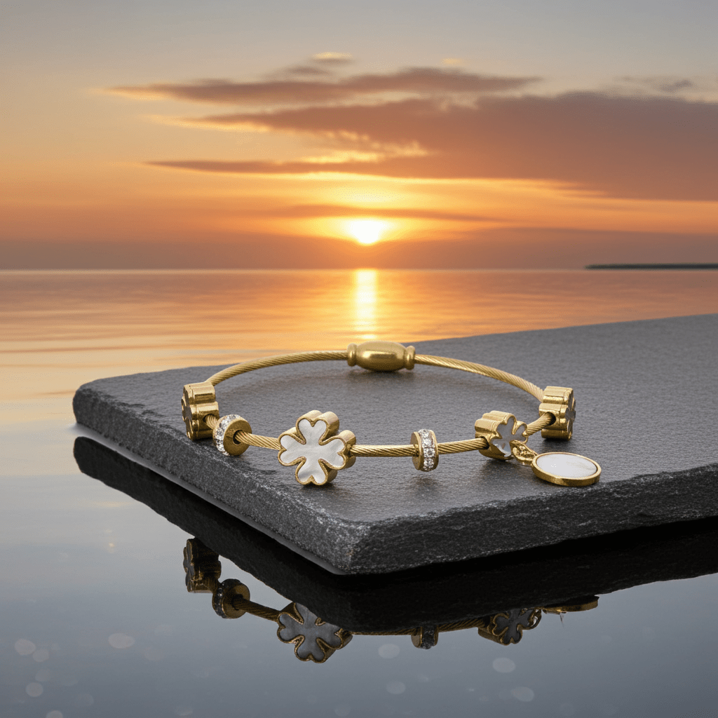 3 leaf charm bracelet with 18k gold plating  on top of a stone.