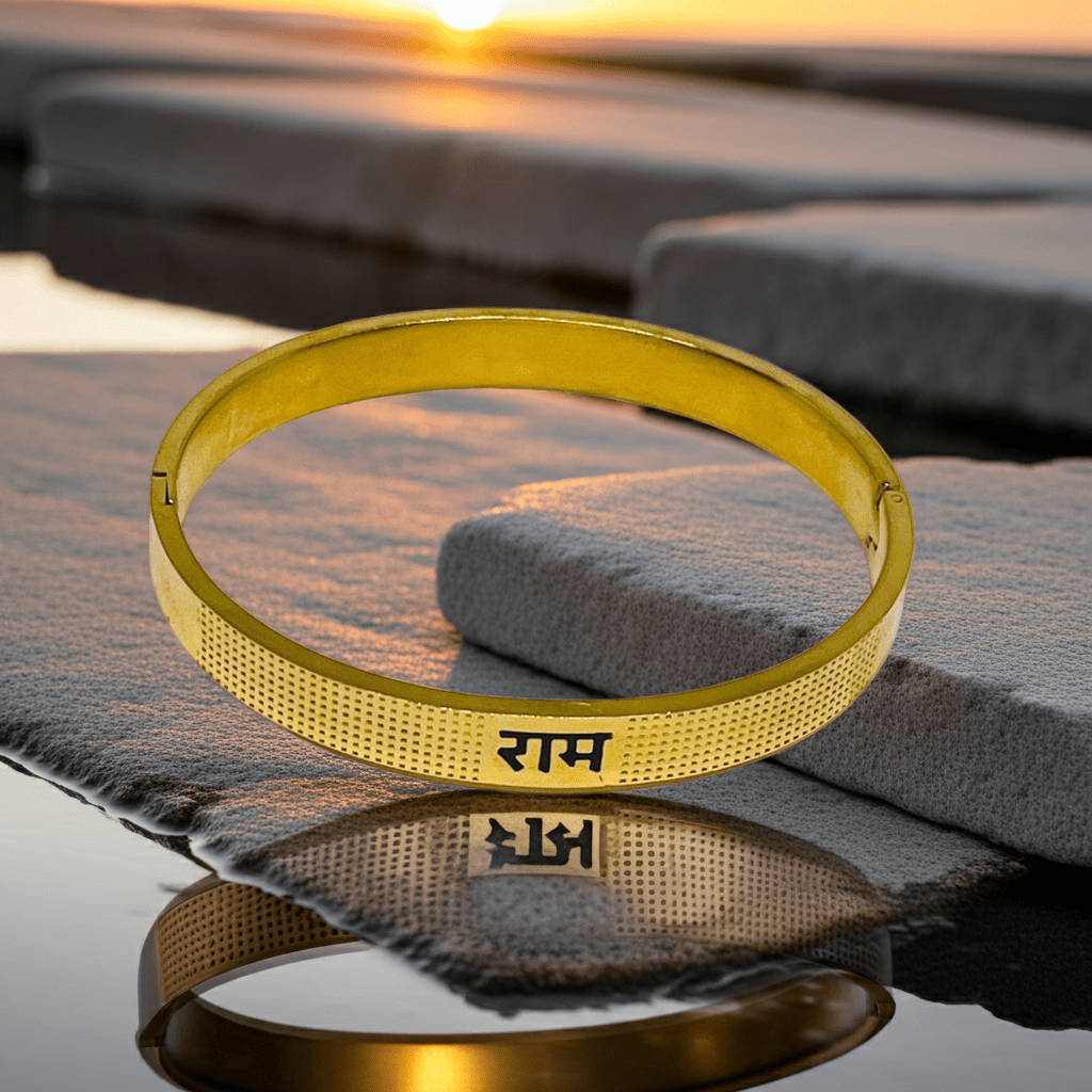Gold bracelet with engraved Ram on a reflective surface at sunset