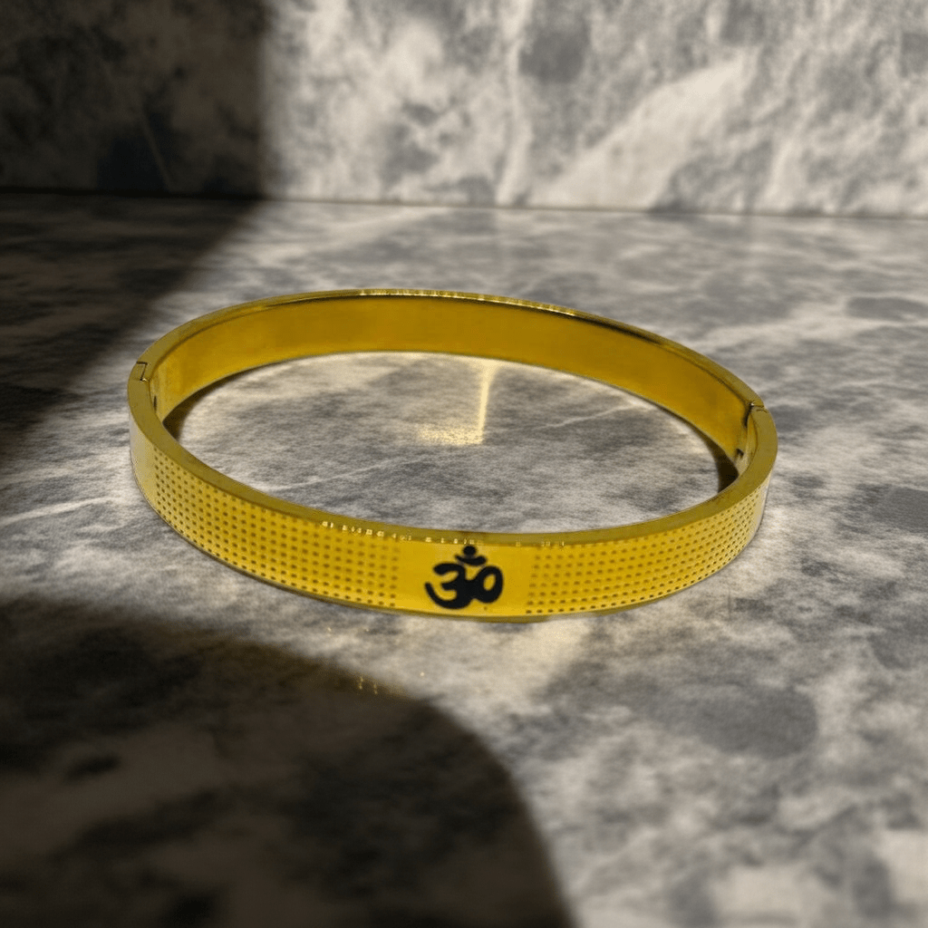 Gold bracelet with a symbol on a marble surface