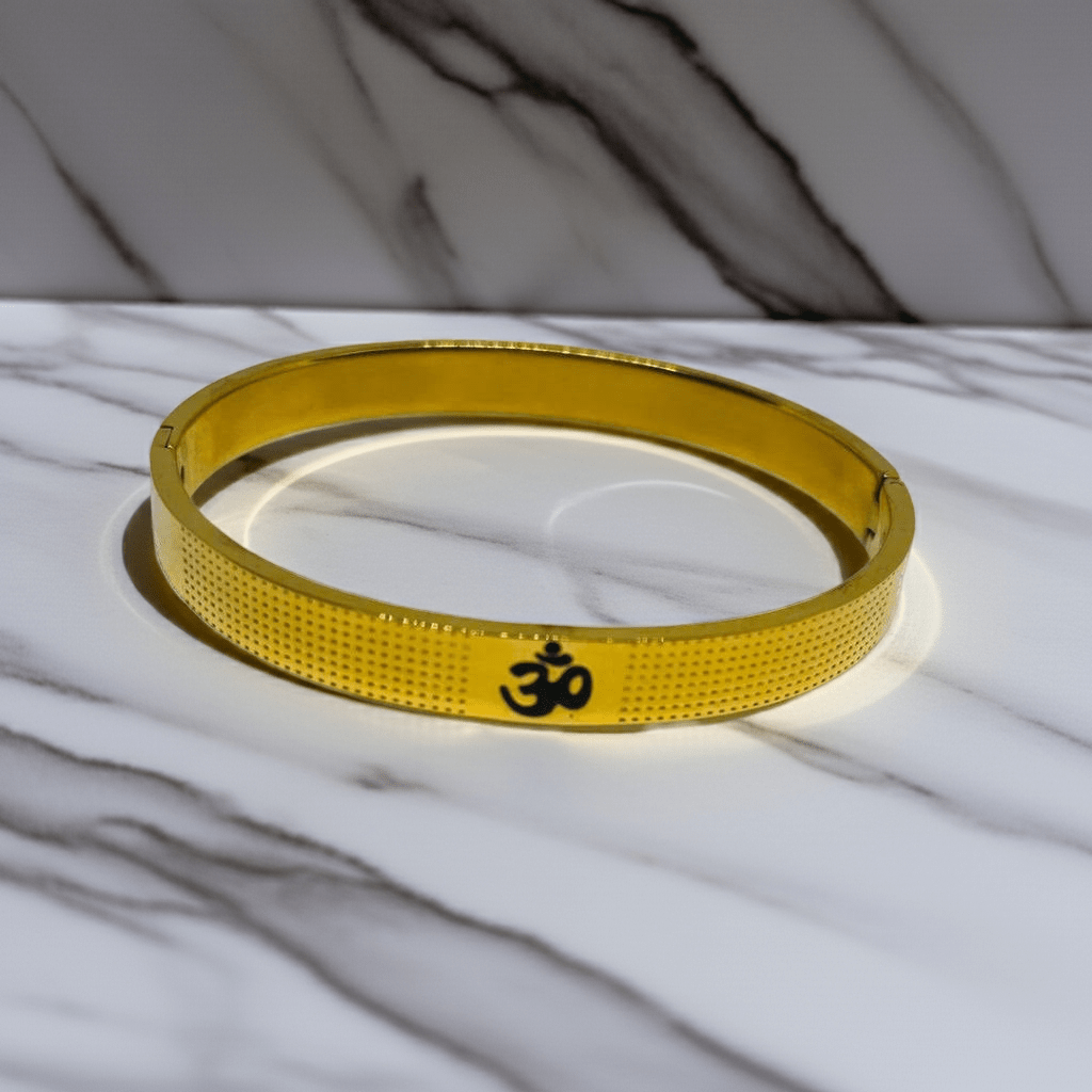 Gold bracelet with a symbol on a marble surface