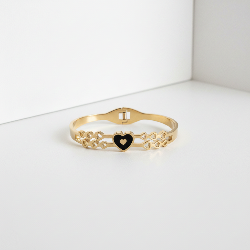 18k Gold bracelet with a black heart charm on a white background