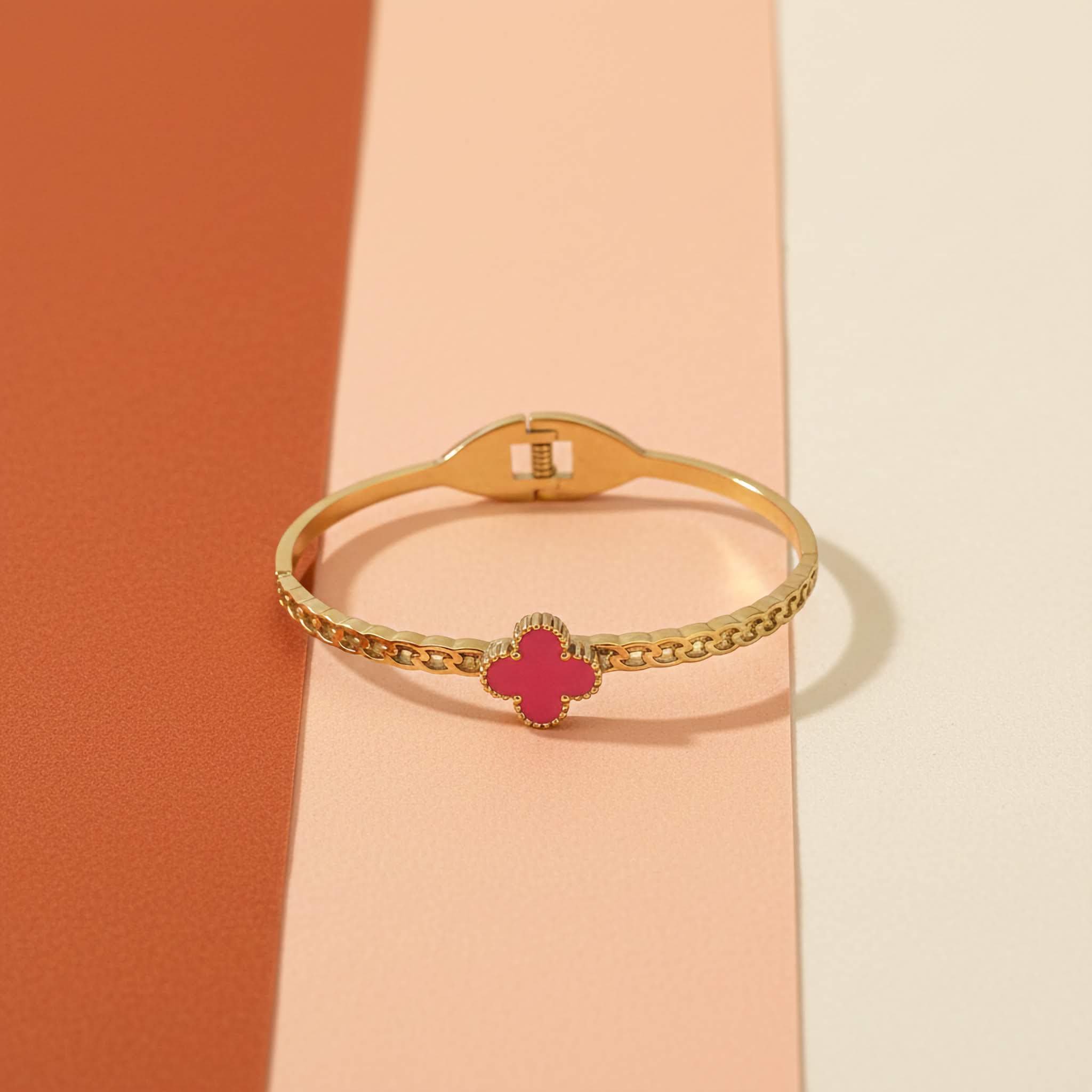 18k Gold plated bracelet with a pink clover charm on a multi-colour background