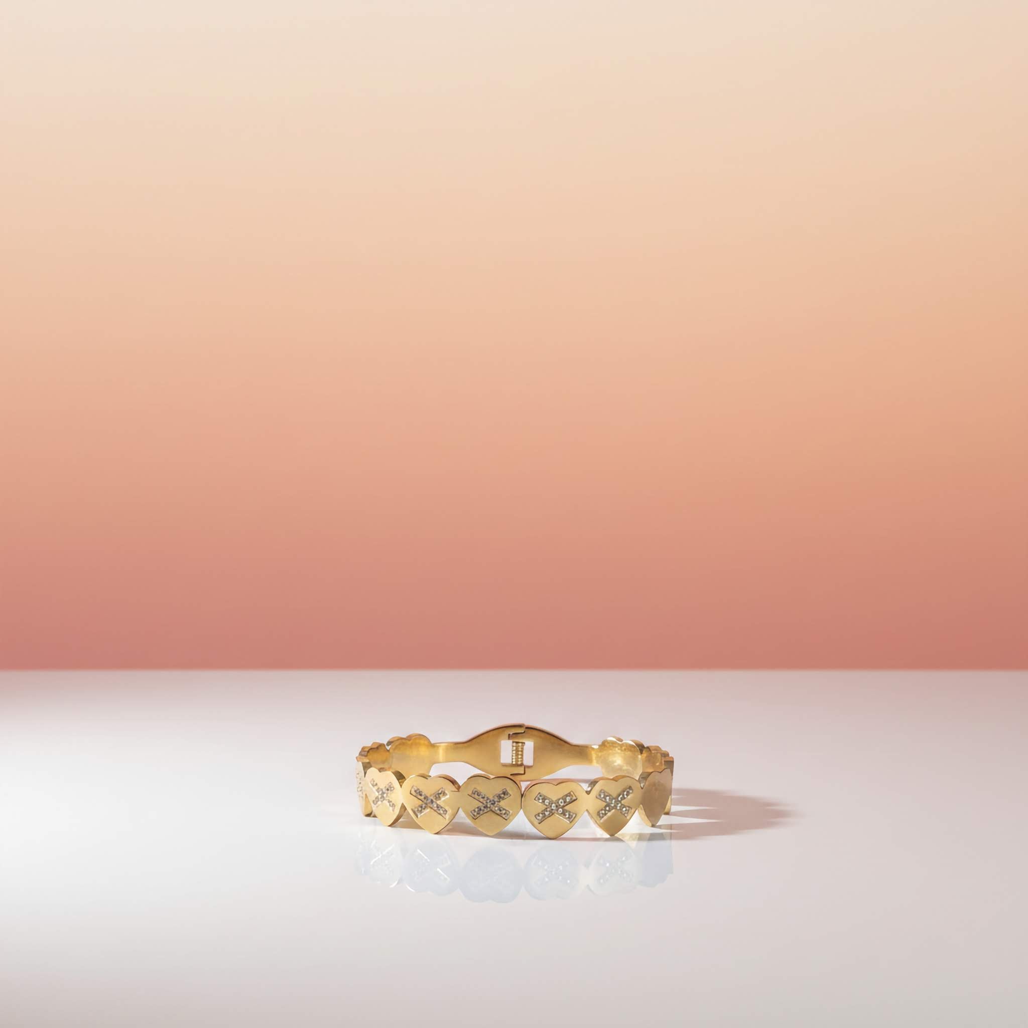 18k gold plated bracelet with heart designs on a gradient background