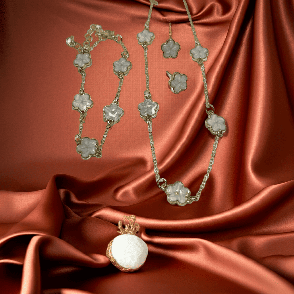Jewelry set with 5 flower white clover necklace, earrings, and pendant on a satin background