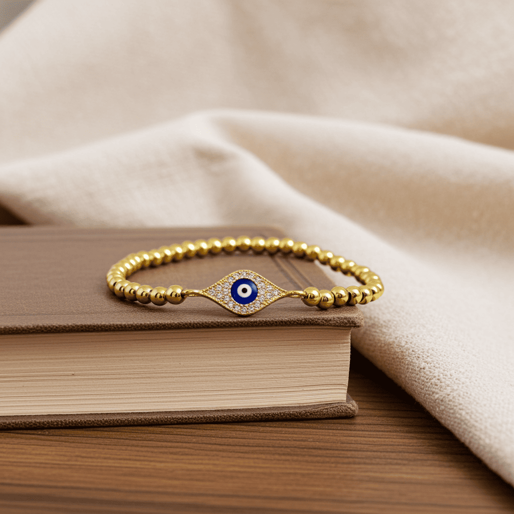 Buy Evil eye slip-on Gold bracelet with a blue evil eye charm on a book
