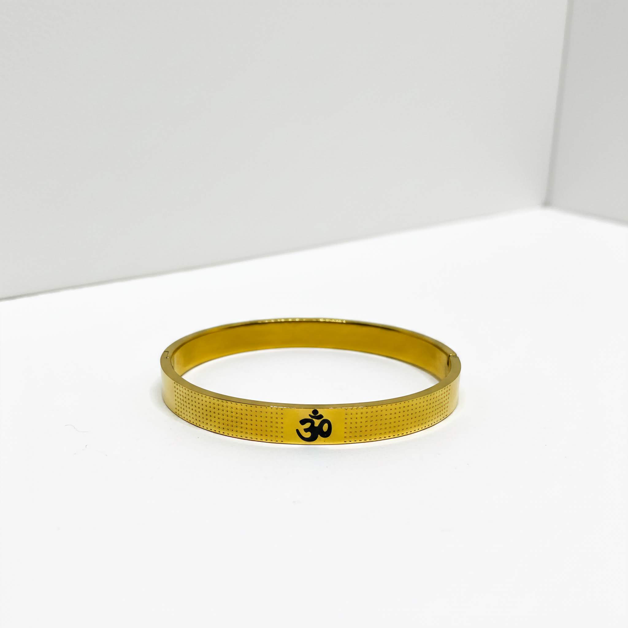Gold bracelet with Om symbol on a white background