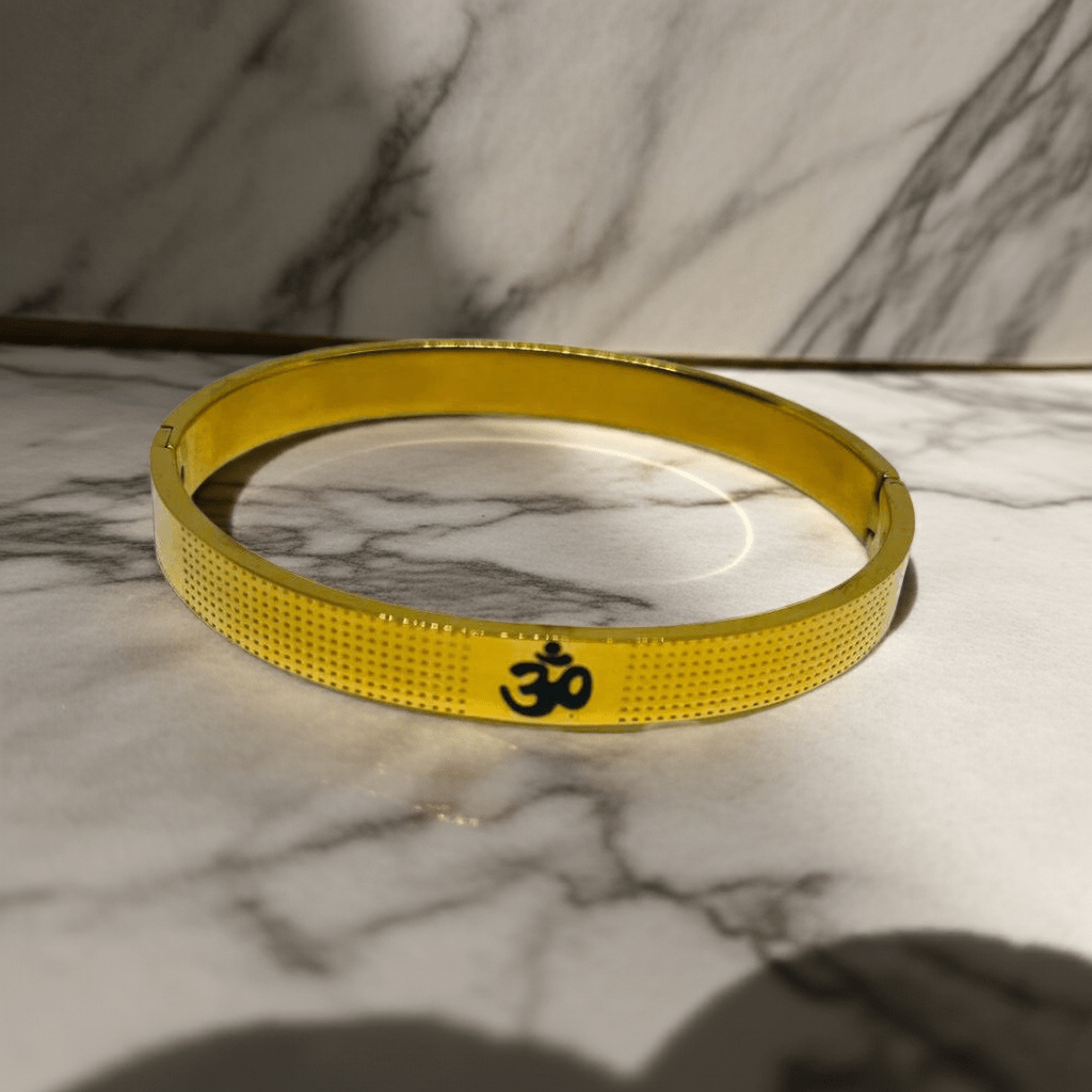 Gold bracelet with a symbol on a marble surface