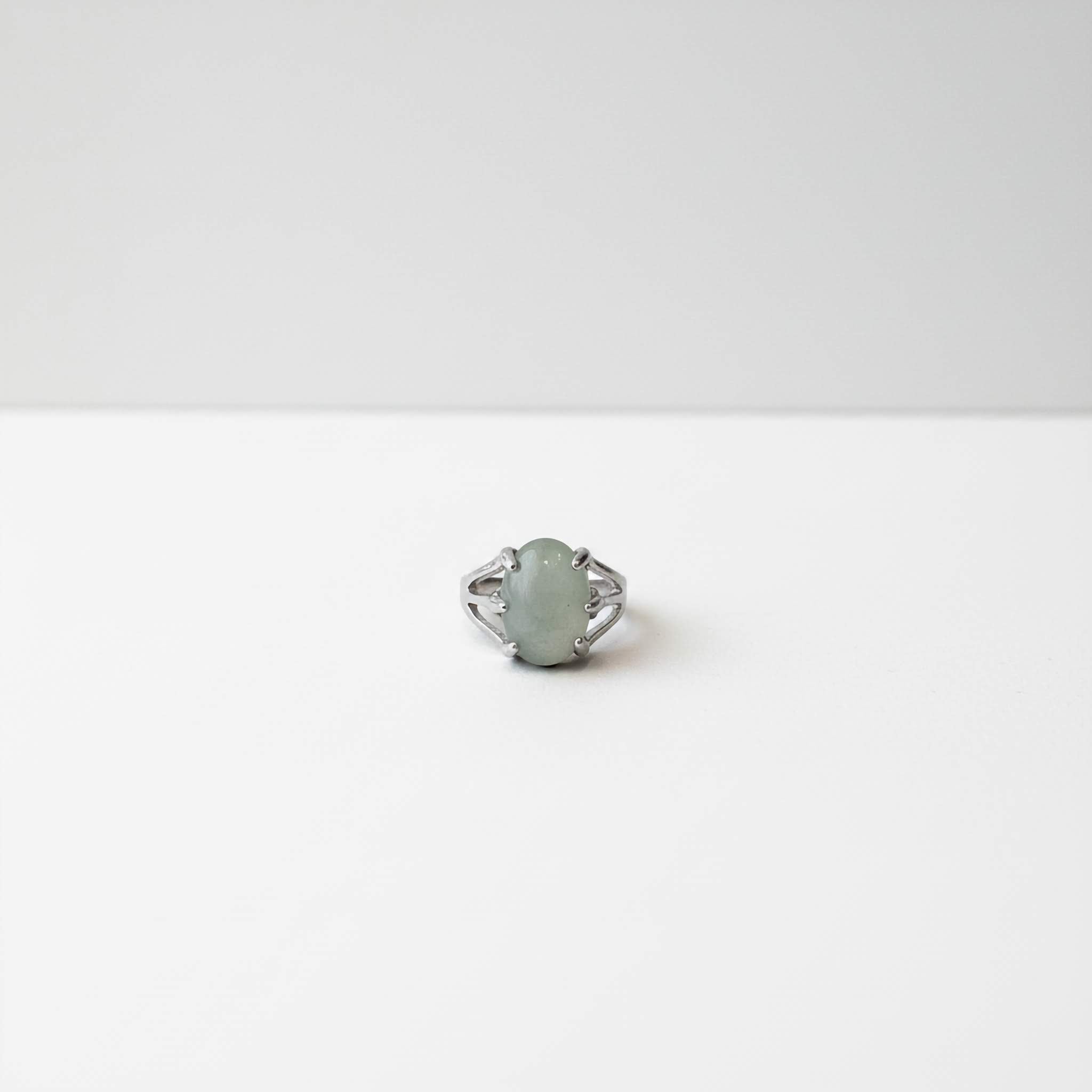 Ring with a light green stone on a white background