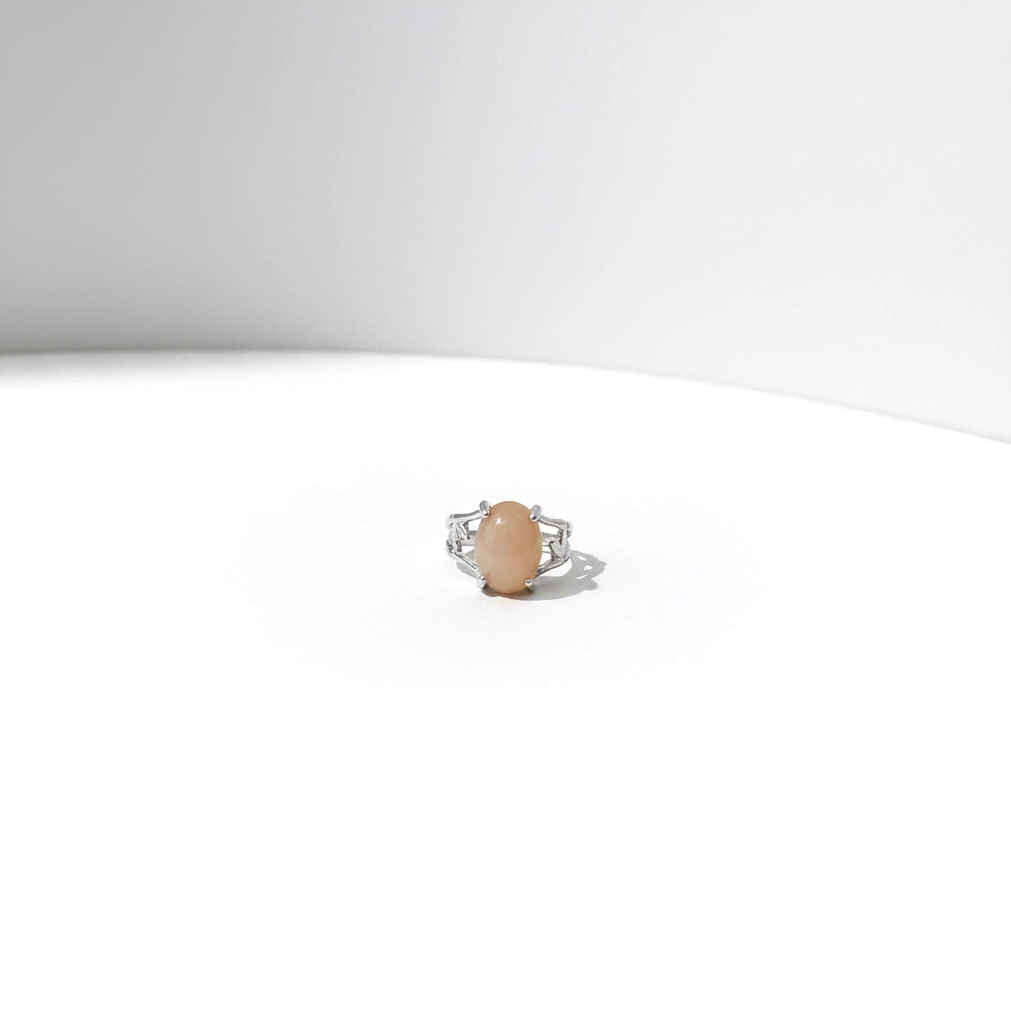 Ring with a peach-coloured stone on a white background