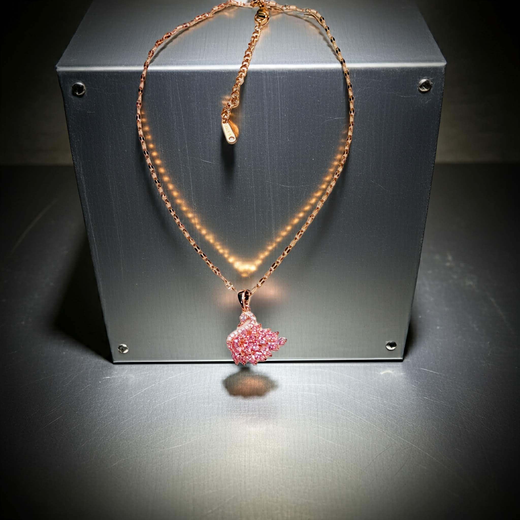 Swarovski pendant Necklace with a pink swan on a metallic surface