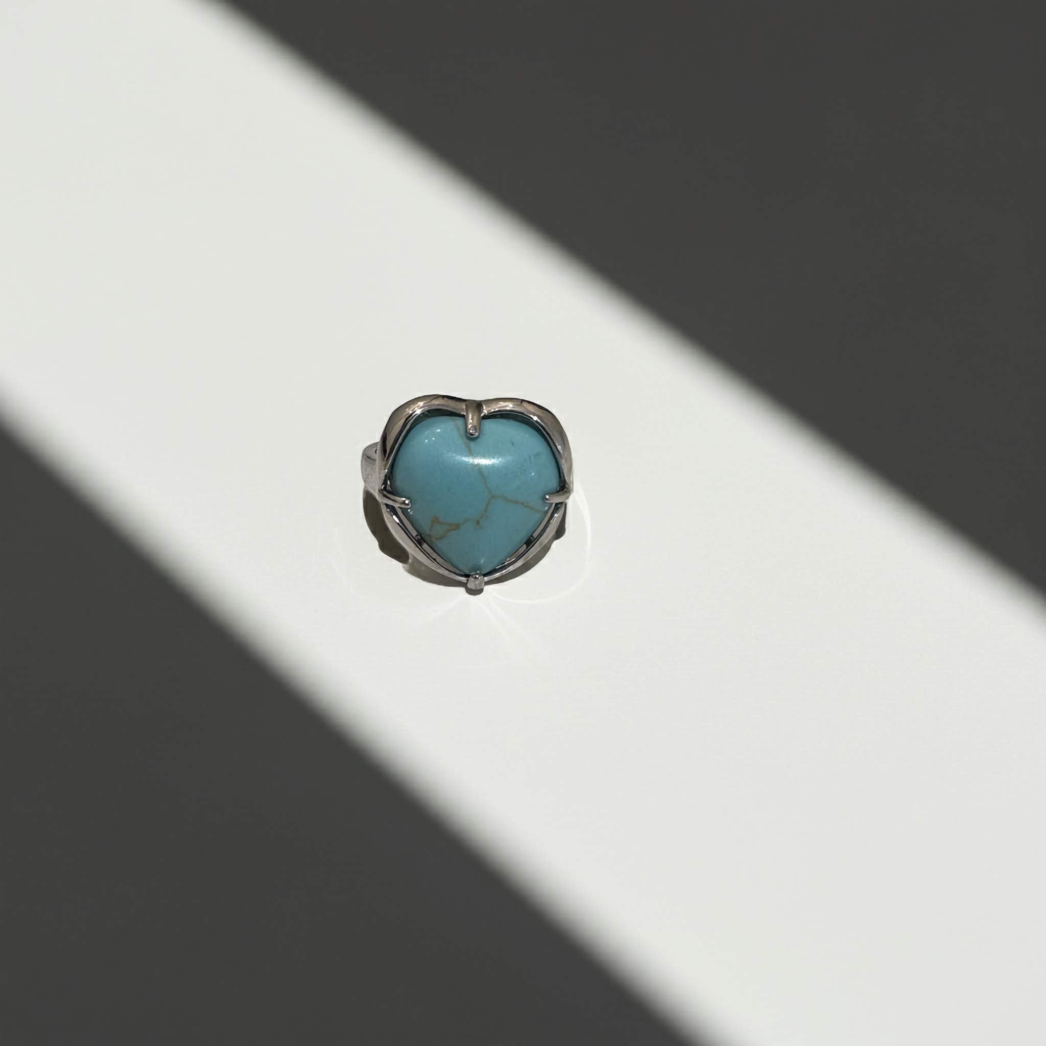 Turquoise heart-shaped stone ring on a white background