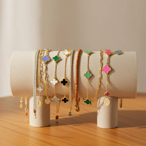 Set of colorful clover bracelets on a wooden surface with a neutral background