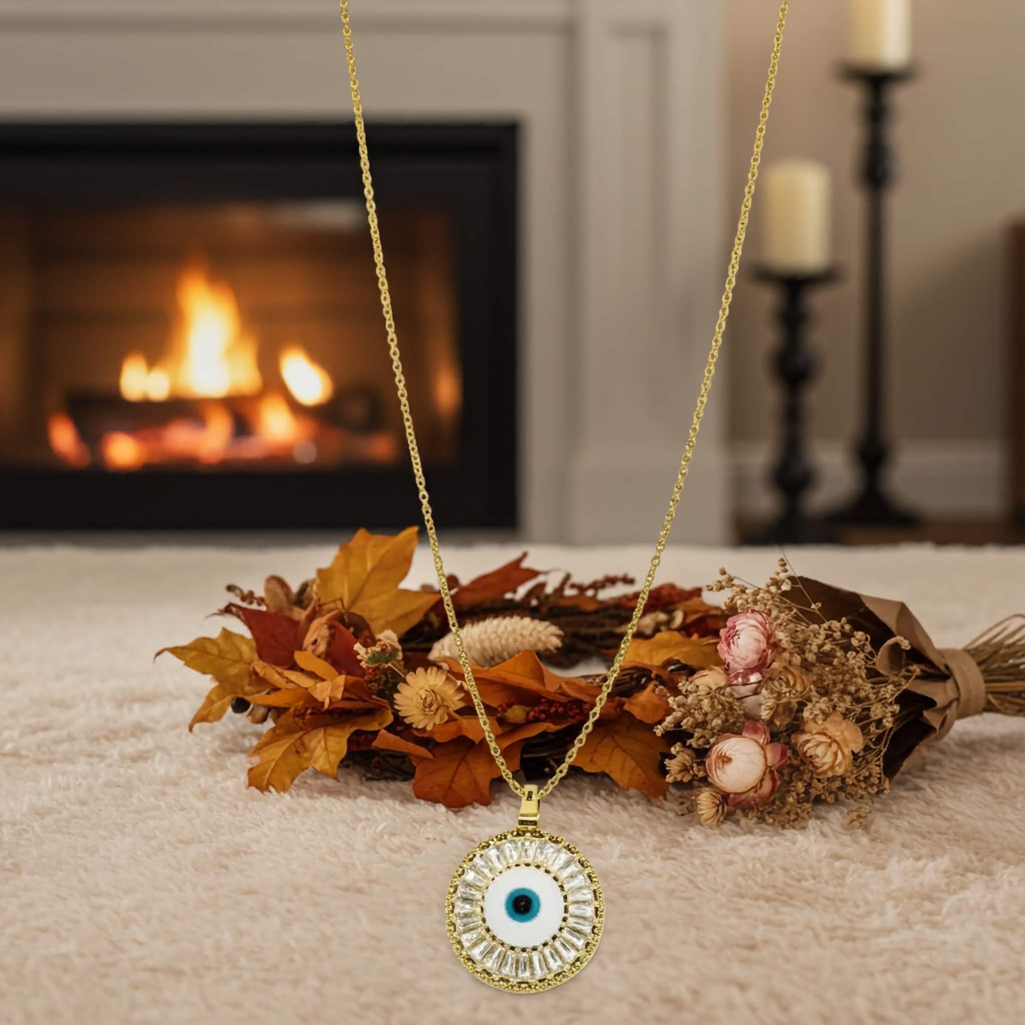 A evil eye Gold necklace with an eye pendant on a surface with autumn leaves and flowers, fireplace in the background