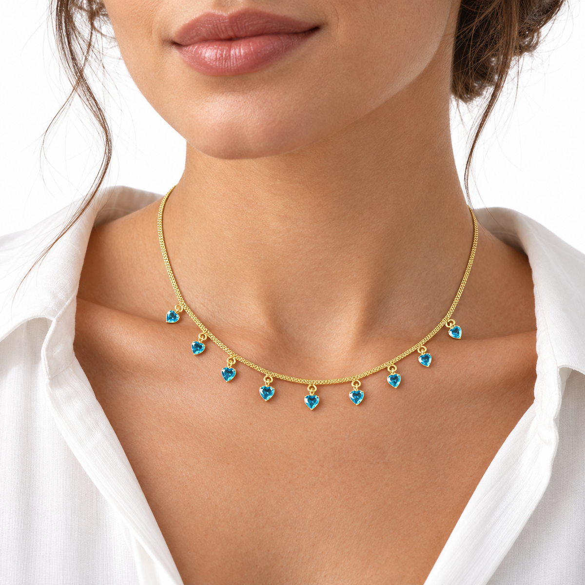 Model wearing LeDeSaRa gold-tone necklace with aqua blue heart charms