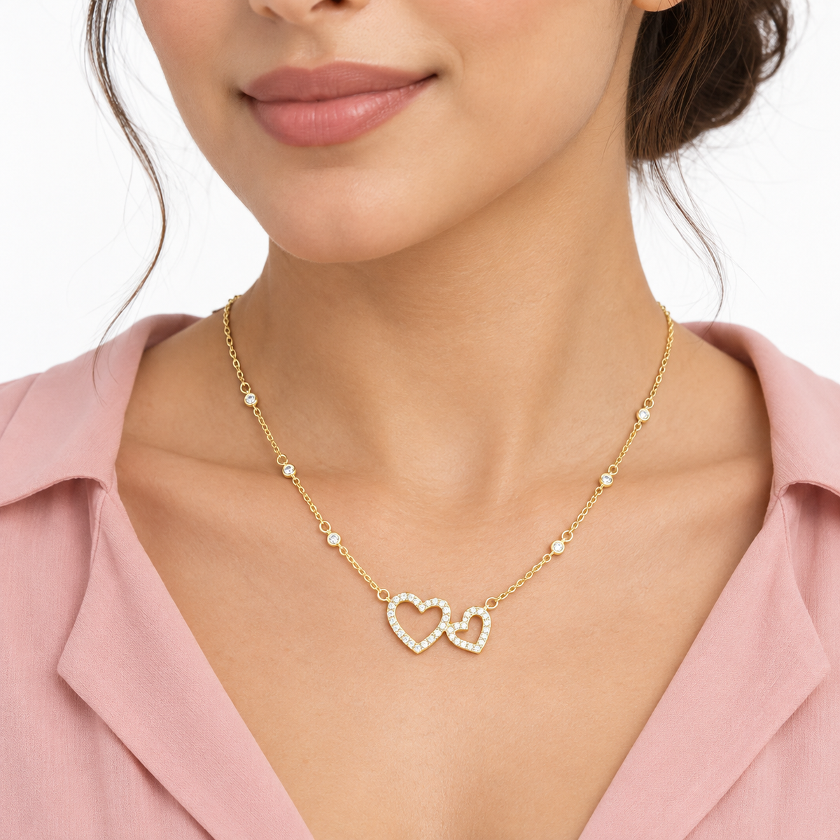 Model wearing LeDeSaRa gold-plated double-heart AD stone necklace with a blush pink blouse
